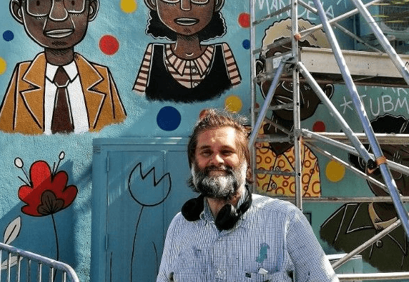 Yvan Postel devant sa fresque